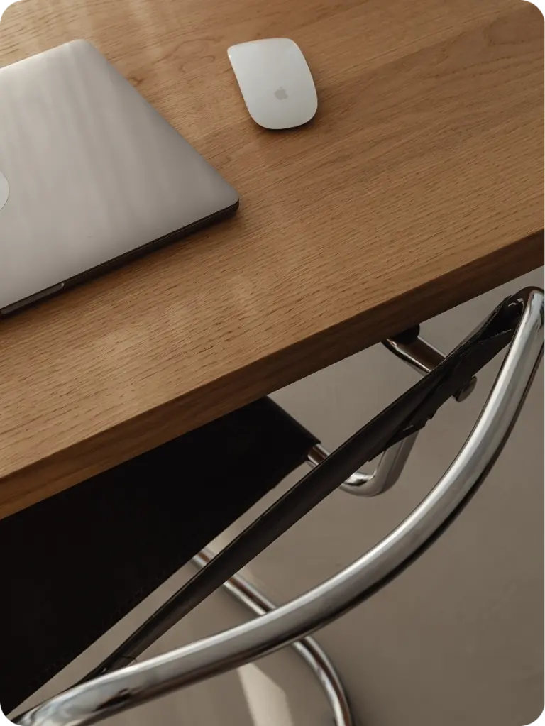 Arbeitsplatz eines Webdesigners mit Laptop, Maus und Stuhl