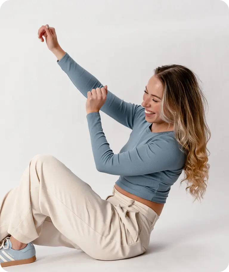 Designerin Anna Sophie Menzen lächelnd und tanzend im sitzen