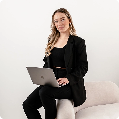 Gründerin Anna Sophie Menzen lächelnd, mit Laptop auf einem Sessel