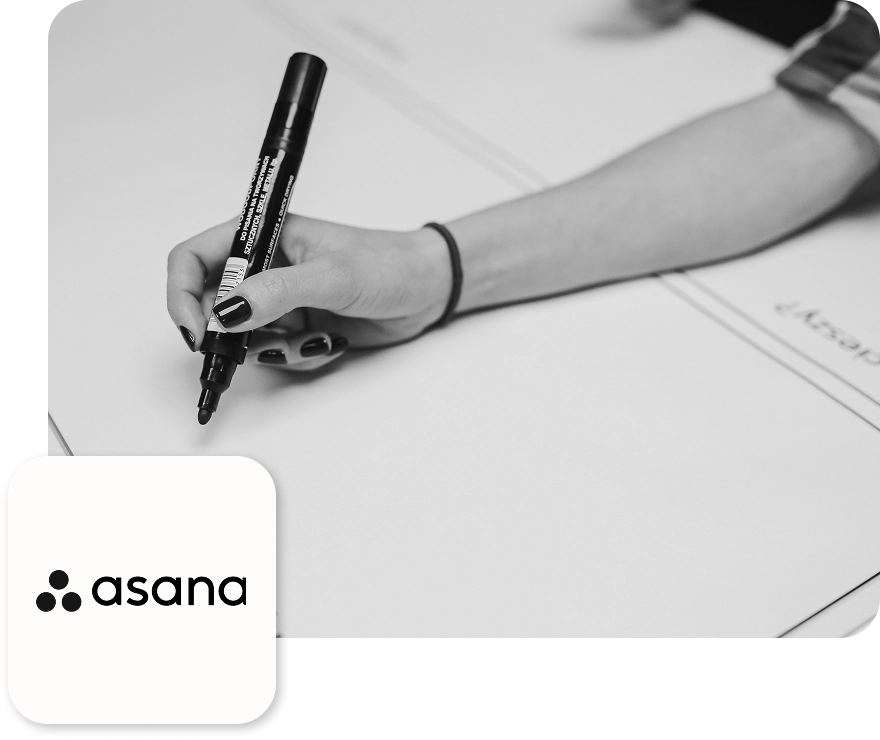 Eine Hand mit einem Filzstift schreibt etwas auf ein Flipchart