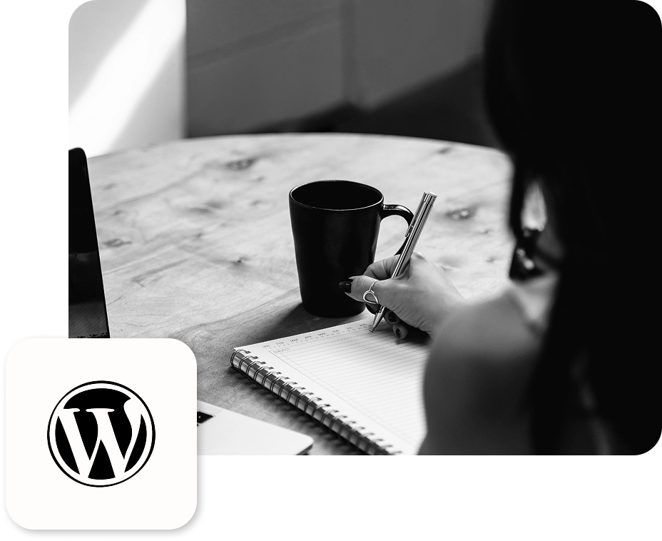 Frau, welche mit einem Stift etwas in ein Notizbuch schreibt