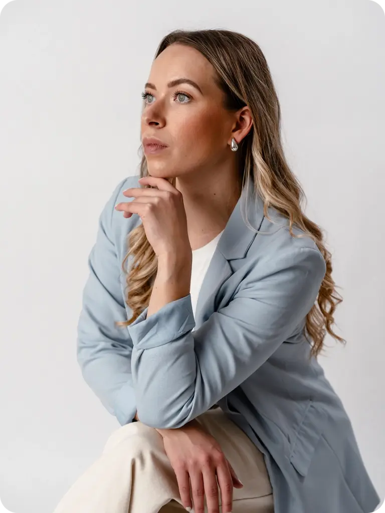 Geschäftsführerin Anna Menzen mit Hand am Kinn und blauem Blazer zur Seite blickend