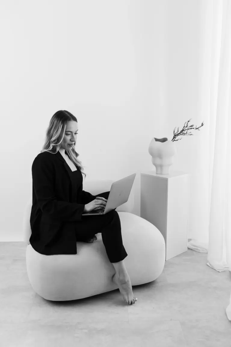 Anna Sophie Menzen, Gründerin von Menzen Designstudio, arbeitet am Laptop auf Sessel