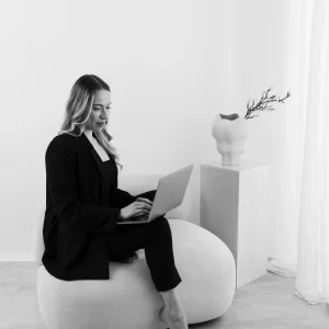 Anna Sophie Menzen, Gründerin von Menzen Designstudio, arbeitet am Laptop auf Sessel